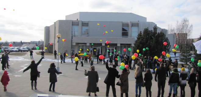 Šventinės eisenos dalyviai prie Angelo skulptūros susikabinę ankomis, sustoję ratu, dainuodami M.Mikutavičiaus 