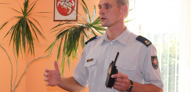 Jurbarko priešgaisrinės gelbėjimo tarnybos vadas Tomas Statkus būrelio nariams pristatė pagrindinę ryšio priemonę - raciją, per kurią iš bendrojo pagalbos centro (112) gaunami pranešimai apie vykstančius incidentus. / Linos Lukošiūtės nuotr.