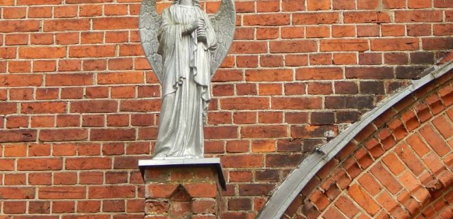 Bažnyčios fasadą puošiantys angelai - gana grakščios figūros, tačiau joms, menininkės R. Grybaitės nuomone, rankose trūksta trimitų.