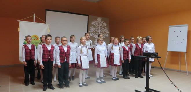 Mokyklos pradinukai dainuoja lietuvių liaudies dainą „Du broliukai“.