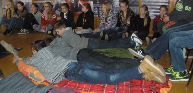 Mokiniai neformalioje apinkoje, susėdę ir sugulę ant iš anksto atsineštų paklotų ir pagalvių, žiūrėjo dokumentinį filmą „Misija Sibiras’ 14“.