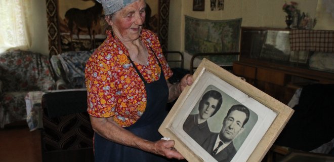 Moters rankose – nuo sienos nukabinta geriausia jos ir jos vyro nuotrauka. Kai Aldona susituokė, jai buvo 23 metai, o jos vyras Antanas buvo vyresnis 18-a metų.