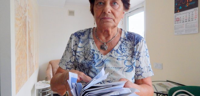 I. Rukšnaitienė rodo šūsnis laiškų, kurie kas mėnesį patenka į nenaudojamo buto pašto dėžutę. / Redakcijos nuotr.