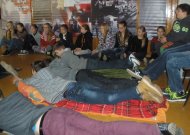 Mokiniai neformalioje apinkoje, susėdę ir sugulę ant iš anksto atsineštų paklotų ir pagalvių, žiūrėjo dokumentinį filmą „Misija Sibiras’ 14“.