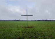 Ūkininkai Robertas Čirvinskas, Simonas Bietkis, Česlovas Petraitis kryžius pastatė prie kelio Jurbarkas - Skaudvilė, netoli Žindaičių gyvenvietės.